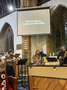 Interior of church with people singing and playing guitar and keyboard