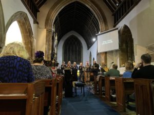 Interior of church with congregation and handbell ringers