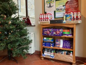 Christmas tree and shelves containing Christmas selection boxes and chocolate santas