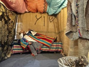 child wearing biblical clothes lying in a tent